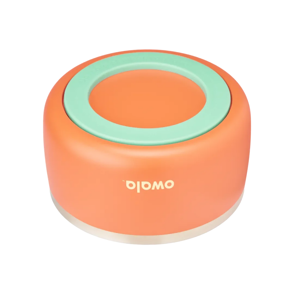 Owala Pet Bowl, bottom view showing orange silicone cup exterior with mint green accent ring embossed with "Do more of what you love" and thin stainless steel band at rim, cream Owala logo on cup side